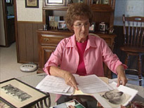 Wilma Roth at home viewing photographs and artifacts.